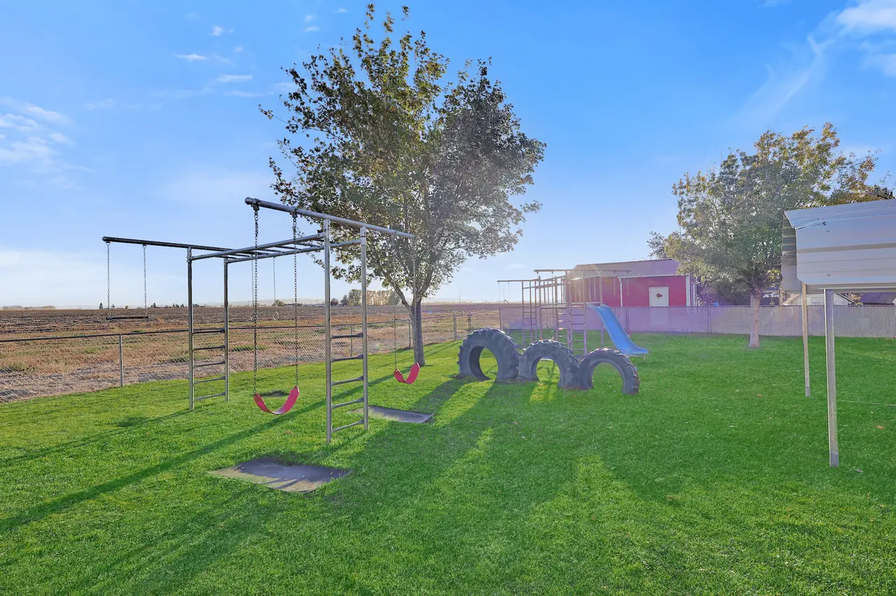 The outdoor play area with playground and mature trees at Lorraines Daycare in Burley, Idaho